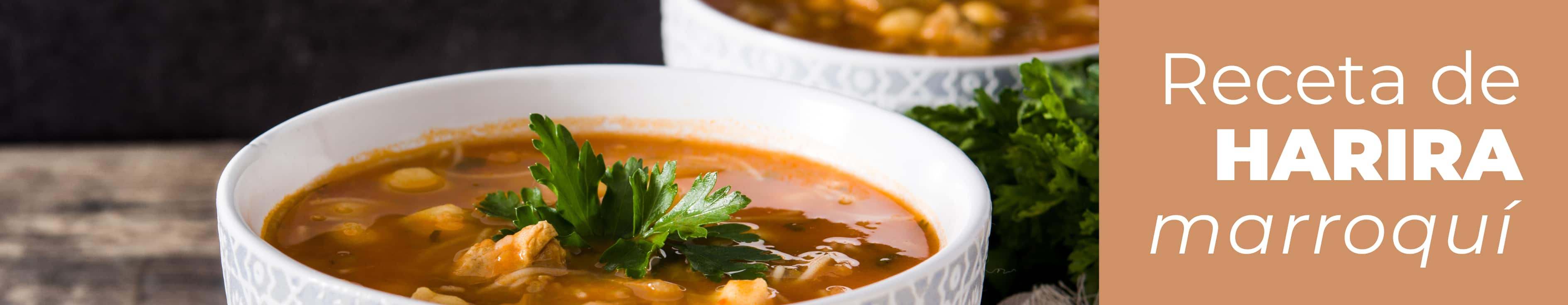 Cuenco de sopa harira marroqui servido caliente con garbanzos y cilantro fresco en la mesa.