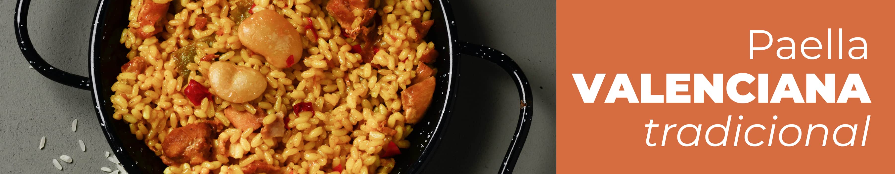 Paella valenciana tradicional terminada en la paellera con pollo, garrofó y judías verdes sobre mesa de madera