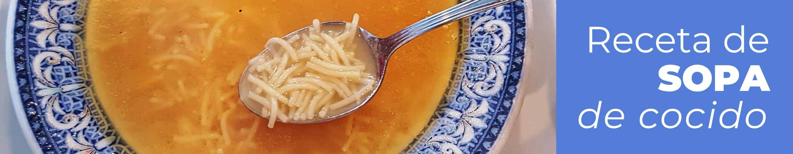 Plato hondo de sopa de fideos con caldo de cocido, garbanzos y huevo picado servido en la mesa.