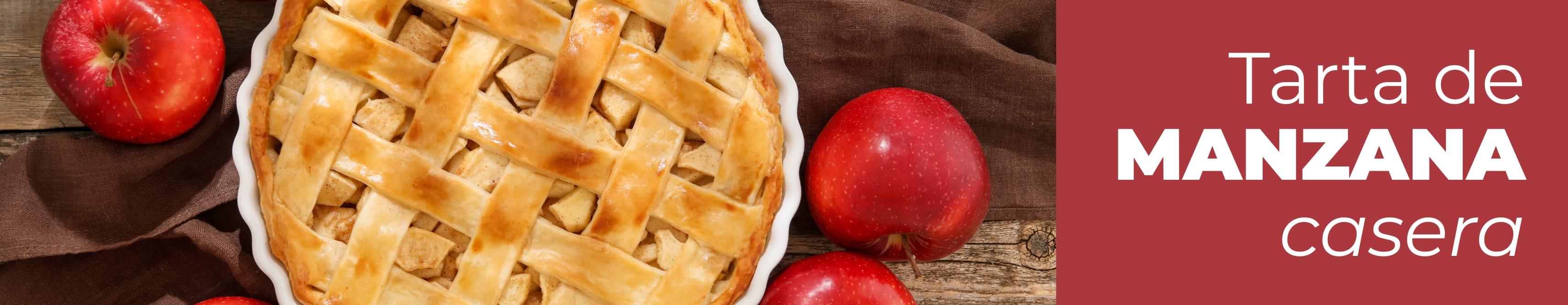 Tarta de manzana casera recién horneada con rejilla de hojaldre dorado junto a una manzana roja